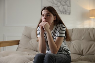 Photo of Depressed teenage girl on sofa at home