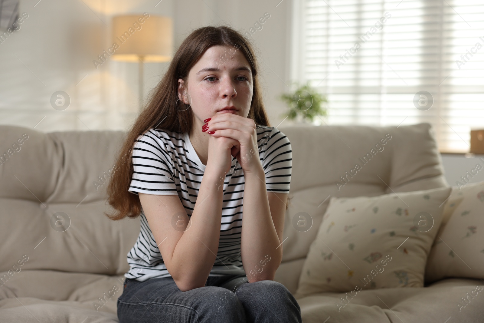 Depressed teenage girl on sofa at home Photo of Depressed teenage girl on sofa at home
