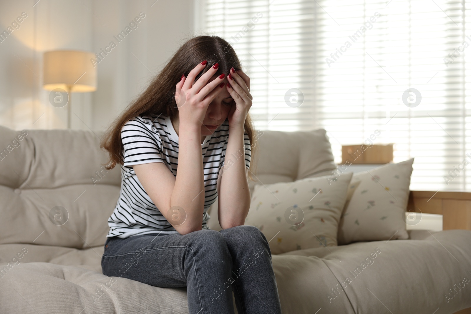 Depressed teenage girl on sofa at home. Space for text Photo of Depressed teenage girl on sofa at home. Space for text