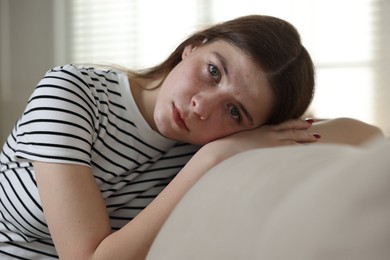 Photo of Depressed teenage girl on sofa at home