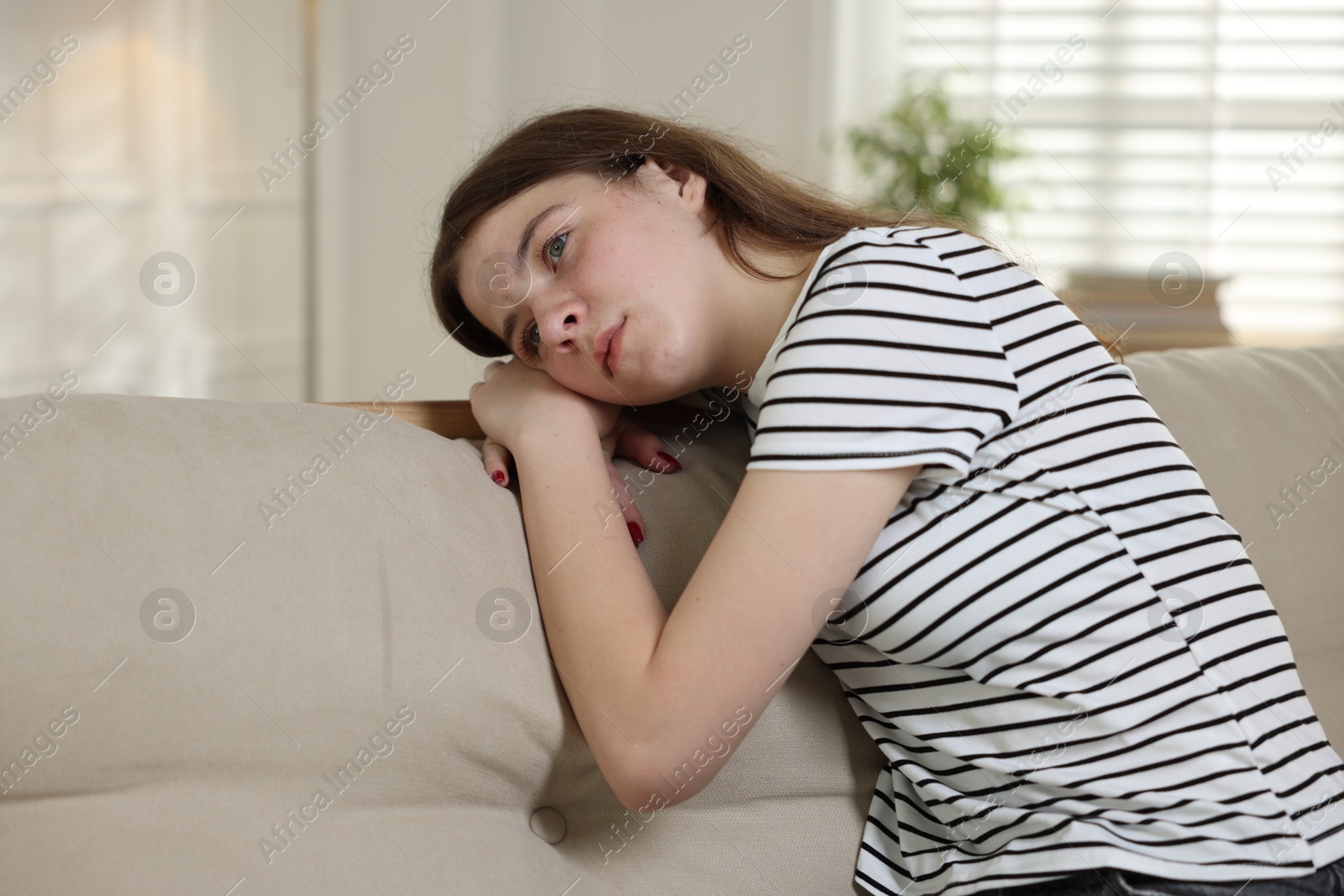 Depressed teenage girl on sofa at home Photo of Depressed teenage girl on sofa at home