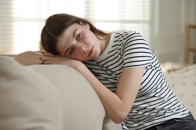 Photo of Depressed teenage girl on sofa at home