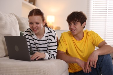 Photo of Teenage students with laptop studying at home