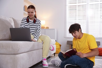 Photo of Teenage students with laptop studying at home