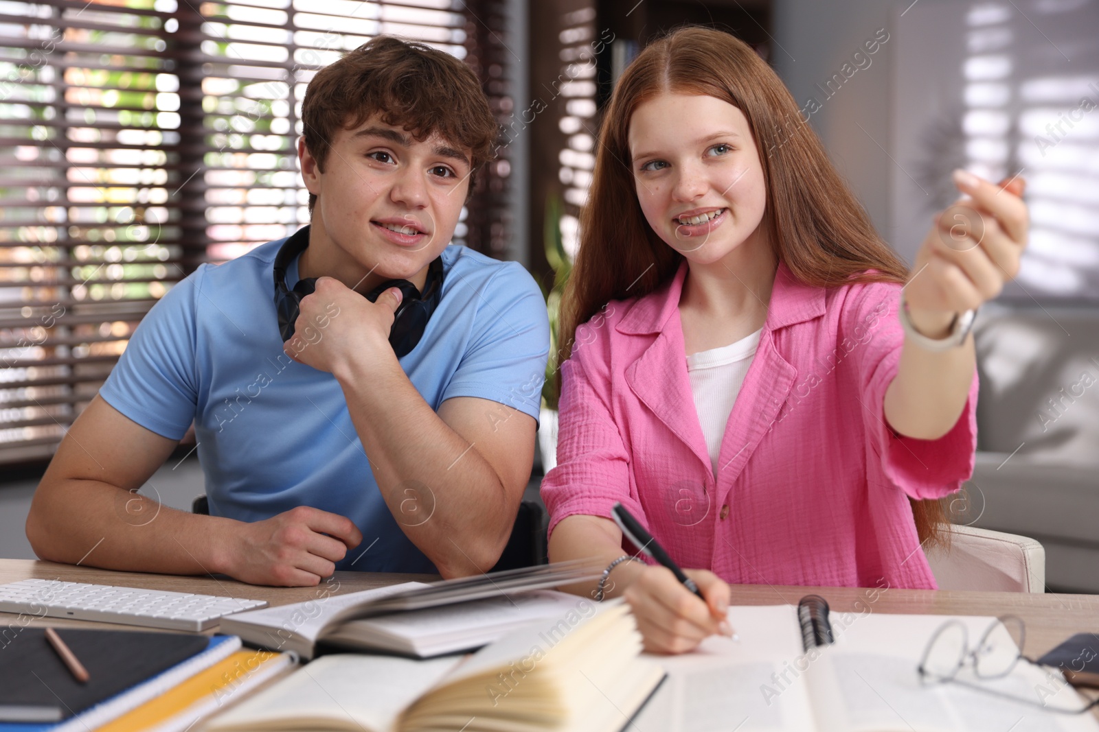 Teenage s students studying together at table indoors Photo of Teenage s students studying together at table indoors