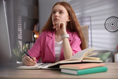 Photo of Teenage student taking notes while studying at table indoors