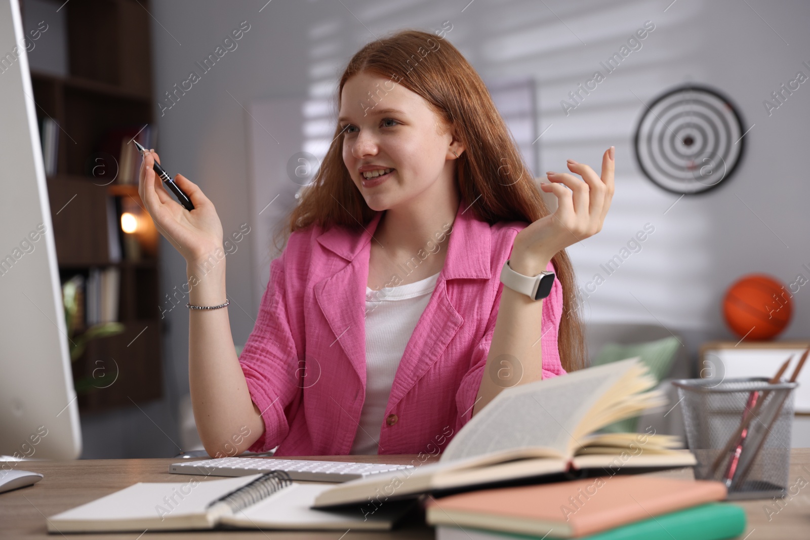 Teenage student using computer while studying at table indoors Photo of Teenage student using computer while studying at table indoors