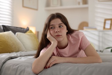 Photo of Upset teenage girl on bed at home