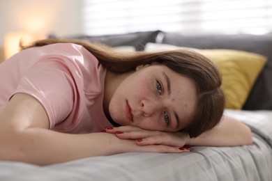 Photo of Depressed teenage girl on bed at home