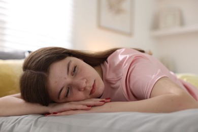 Photo of Depressed teenage girl on bed at home