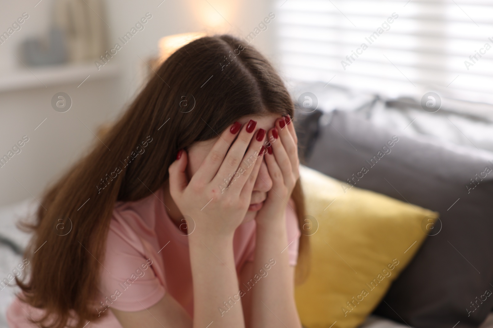 Upset teenage girl on bed at home Photo of Upset teenage girl on bed at home