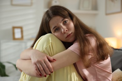 Photo of Depressed teenage girl on bed at home