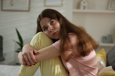 Photo of Depressed teenage girl on bed at home