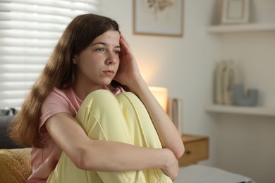 Photo of Depressed teenage girl on bed at home. Space for text