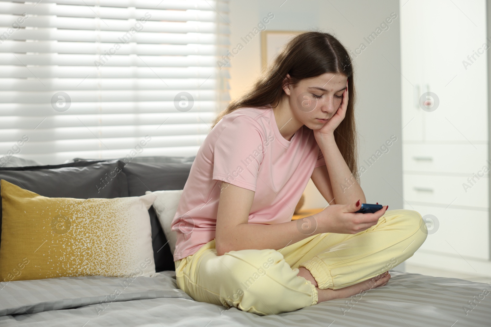 Upset teenage girl on bed at home Photo of Upset teenage girl on bed at home