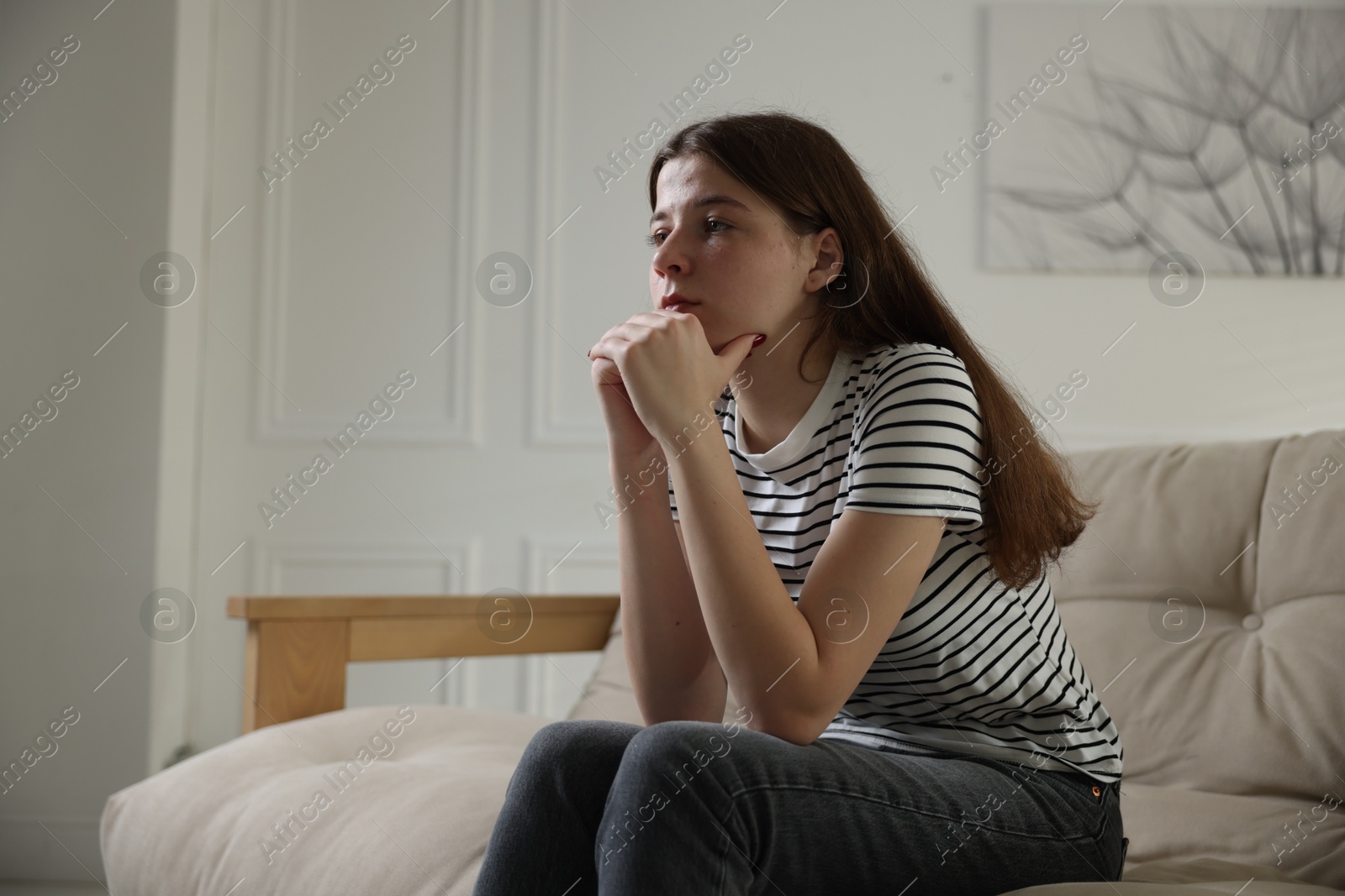 Depressed teenage girl on sofa at home. Space for text Photo of Depressed teenage girl on sofa at home. Space for text