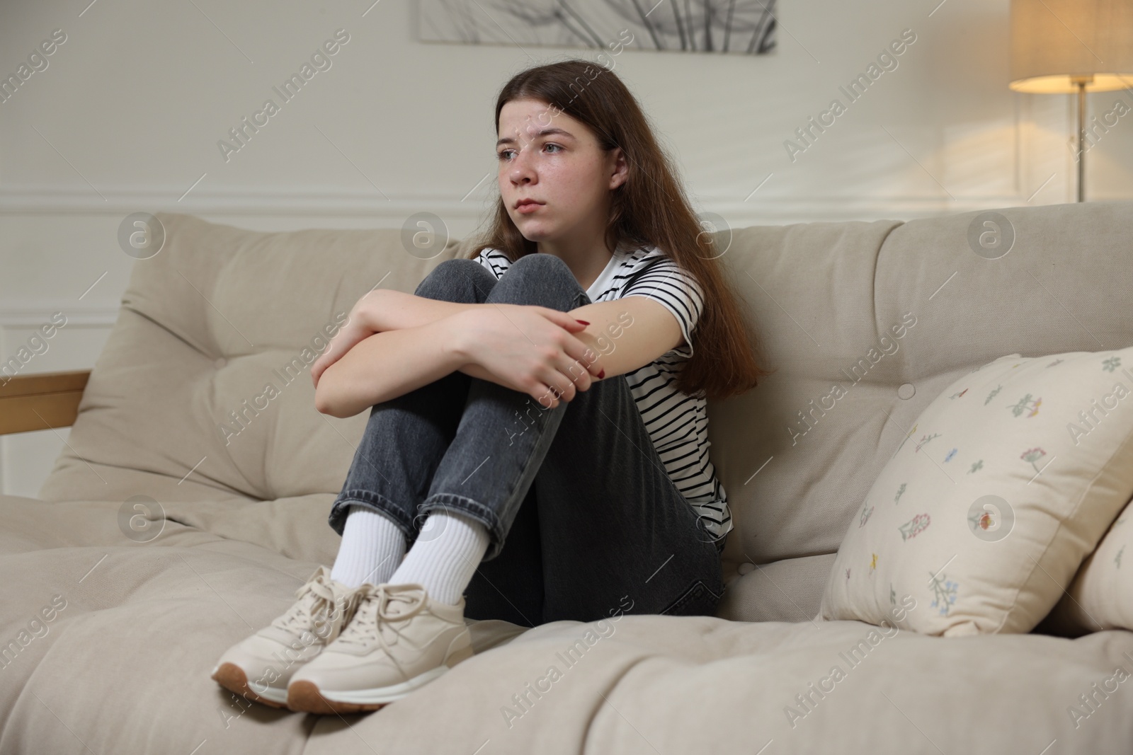 Depressed teenage girl on sofa at home Photo of Depressed teenage girl on sofa at home