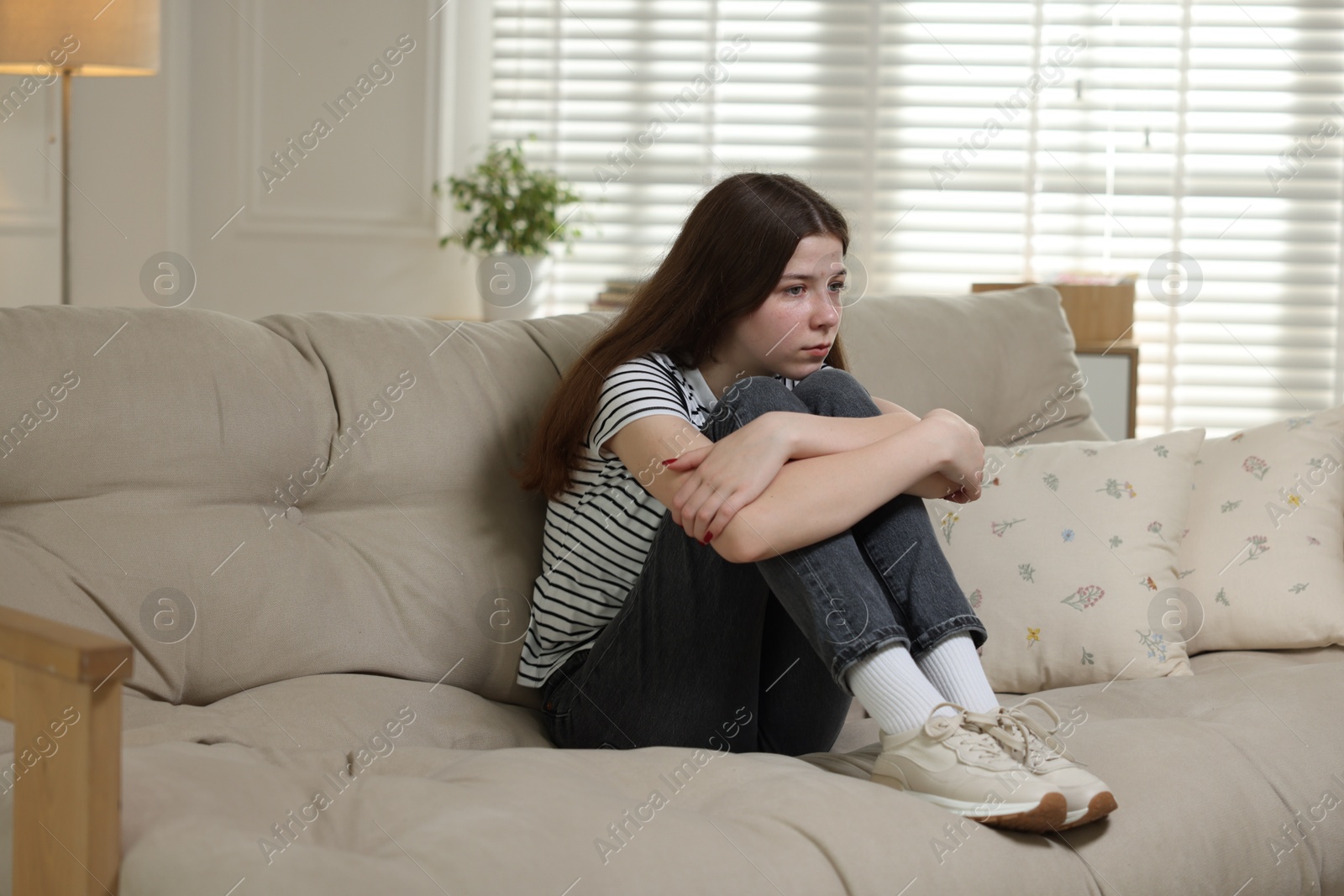 Depressed teenage girl on sofa at home Photo of Depressed teenage girl on sofa at home