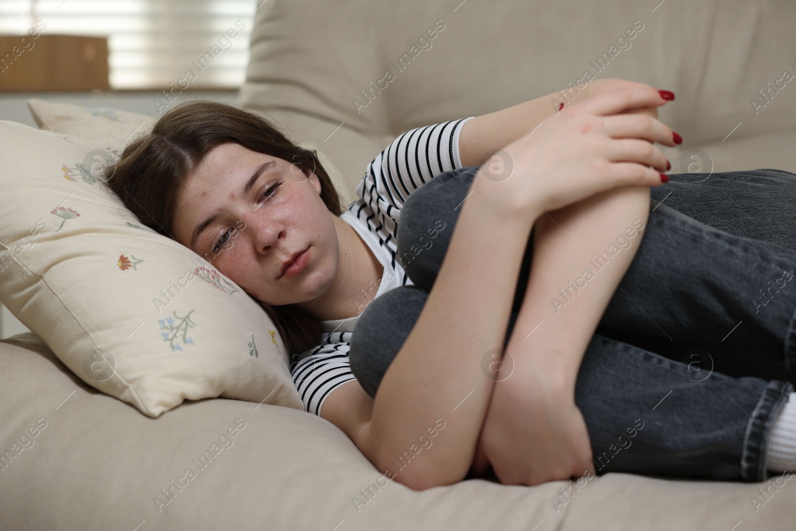 Depressed teenage girl lying on sofa at home Photo of Depressed teenage girl lying on sofa at home