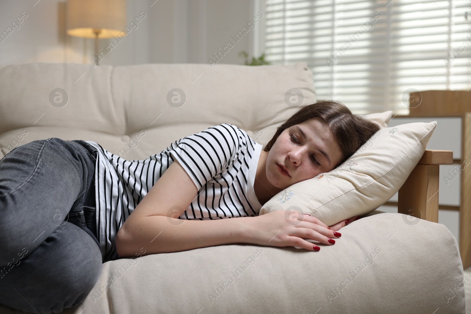 Depressed teenage girl lying on sofa at home Photo of Depressed teenage girl lying on sofa at home