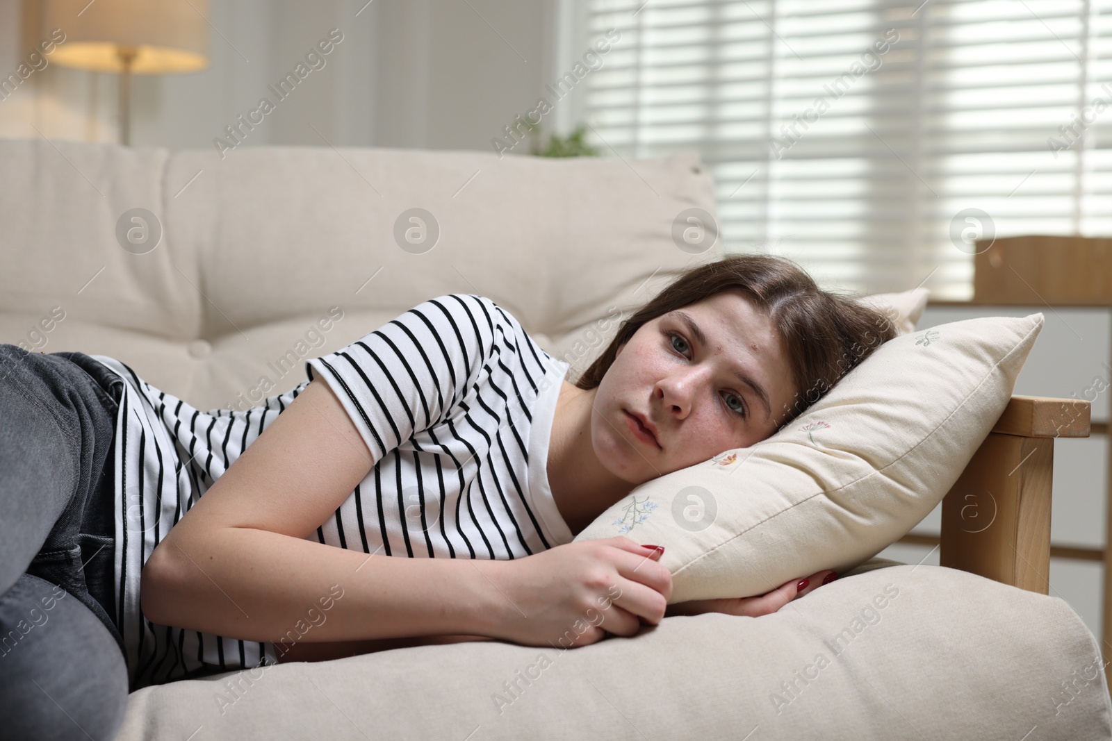 Depressed teenage girl lying on sofa at home Photo of Depressed teenage girl lying on sofa at home