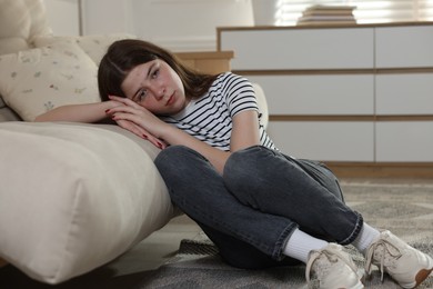 Photo of Upset teenage girl on floor at home