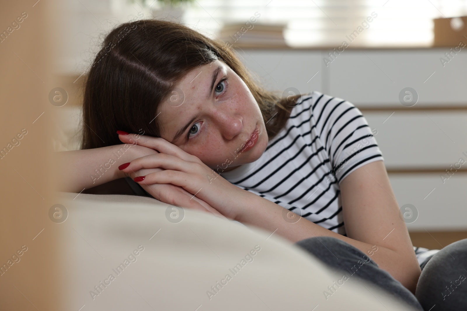 Upset teenage girl on floor at home Photo of Upset teenage girl on floor at home