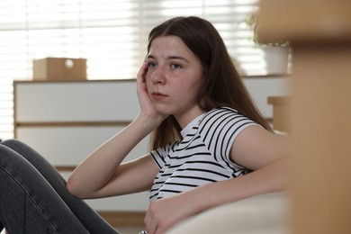 Photo of Upset teenage girl on floor at home