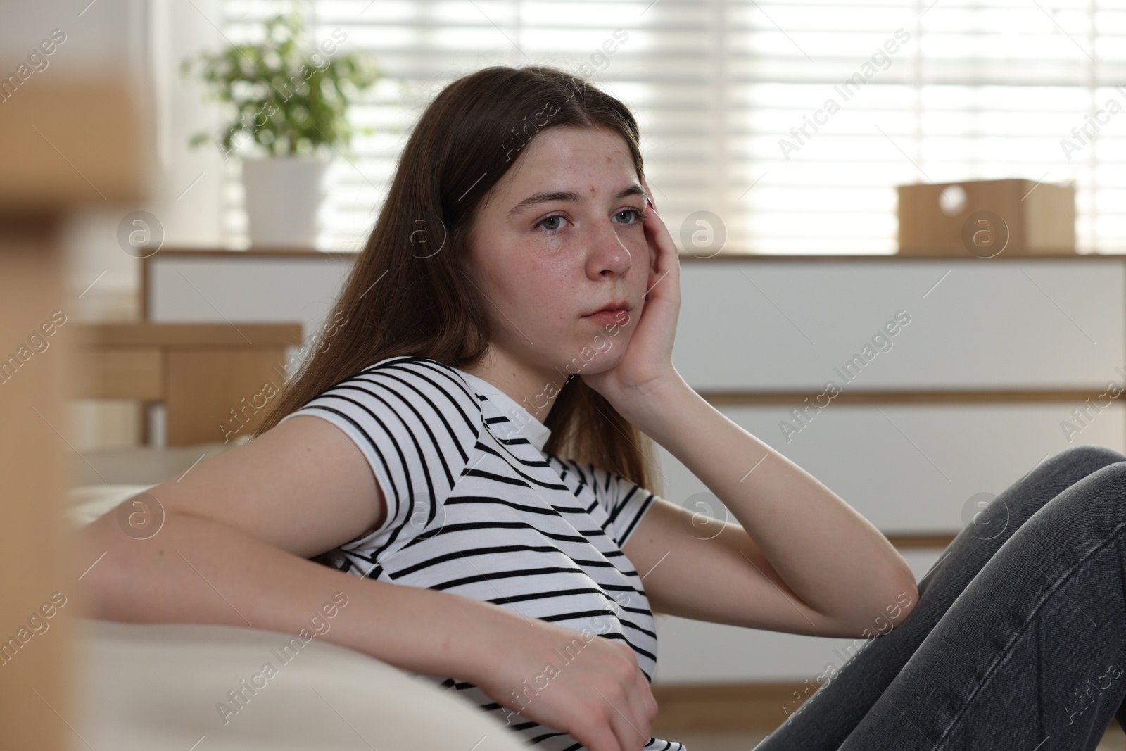 Upset teenage girl on floor at home Photo of Upset teenage girl on floor at home