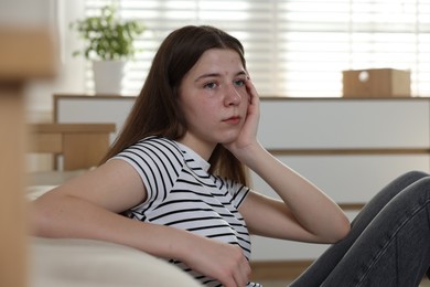 Photo of Upset teenage girl on floor at home