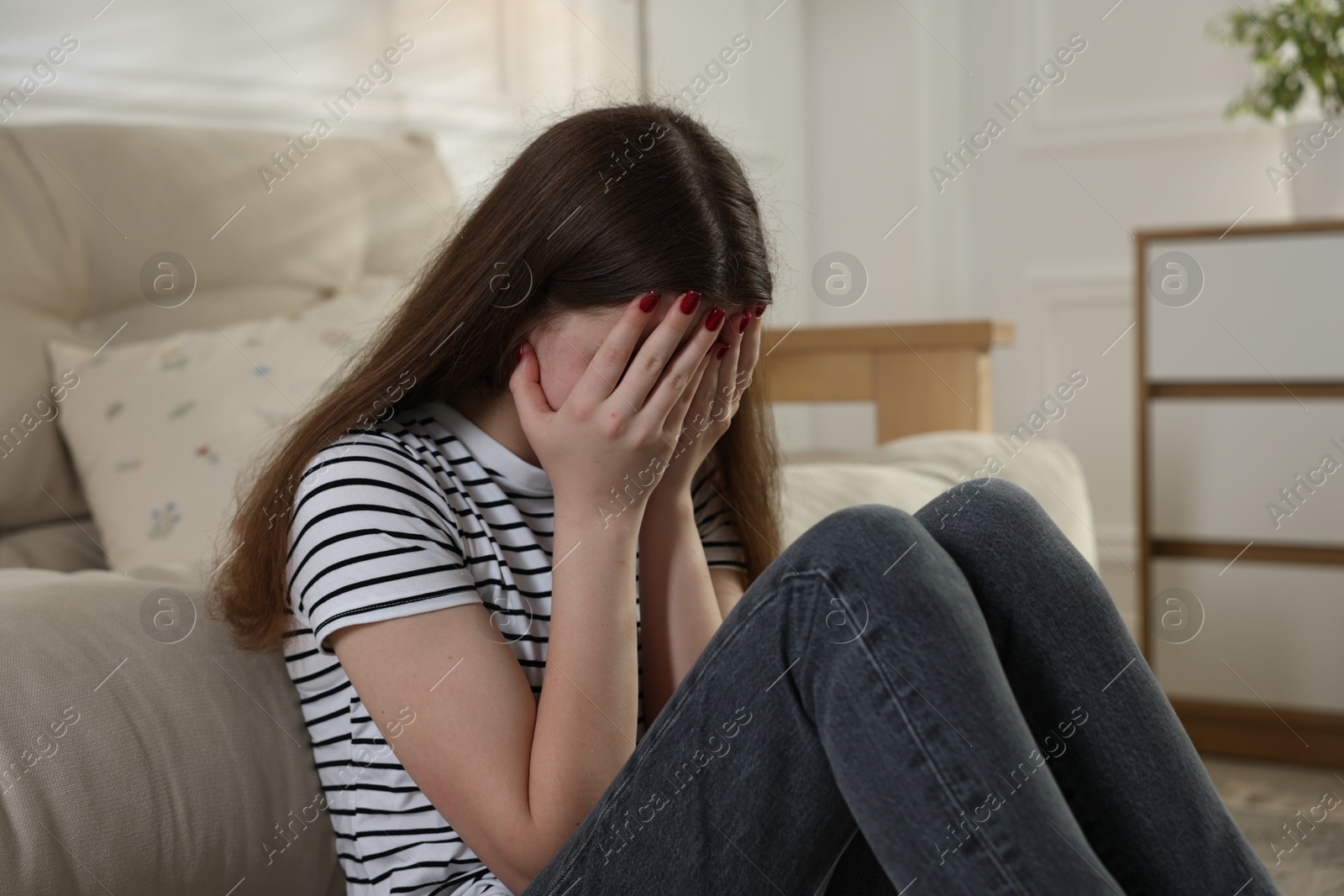 Depressed teenage girl on floor at home Photo of Depressed teenage girl on floor at home