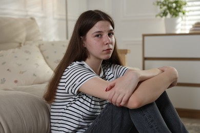 Photo of Upset teenage girl on floor at home