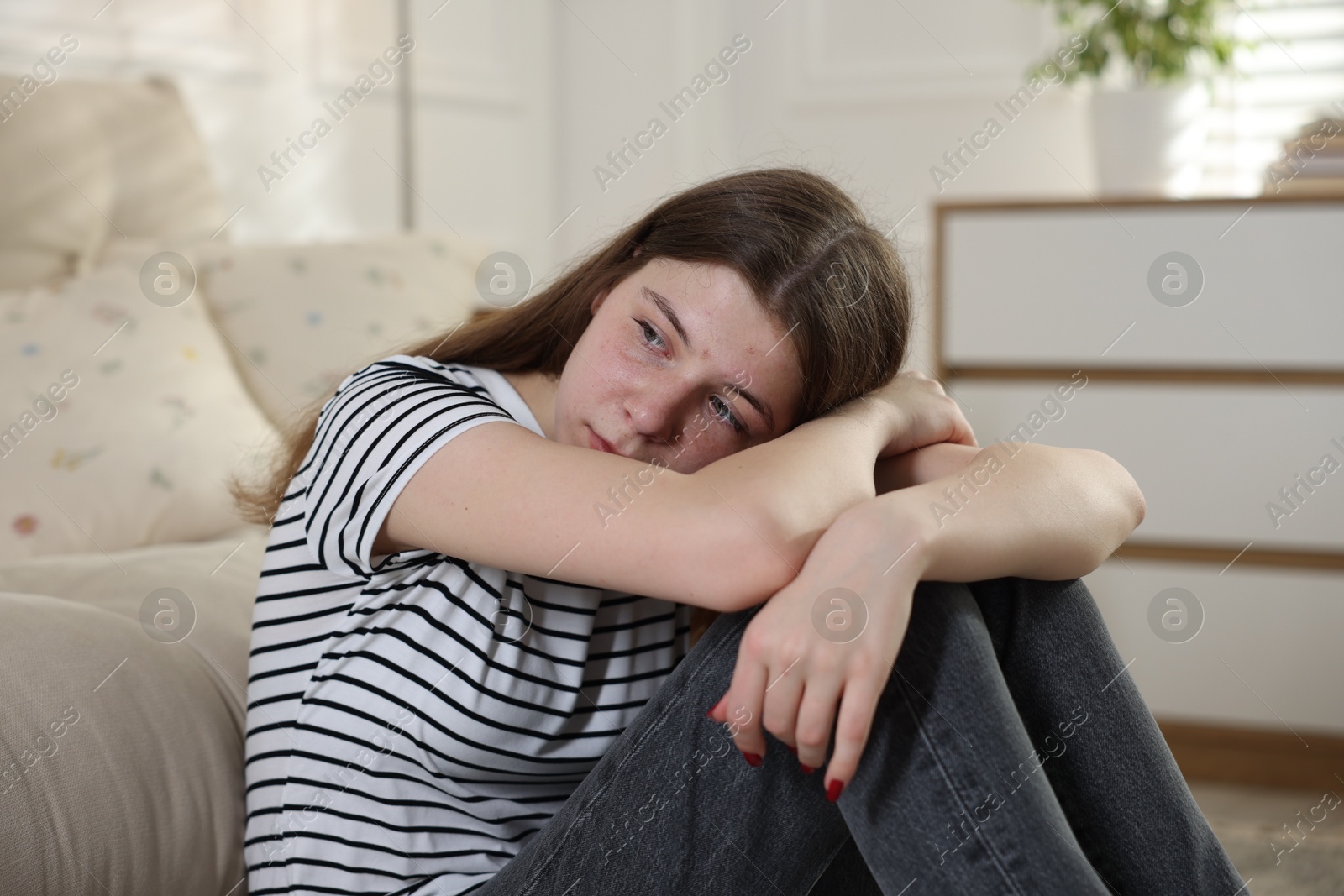Depressed teenage girl on floor at home Photo of Depressed teenage girl on floor at home
