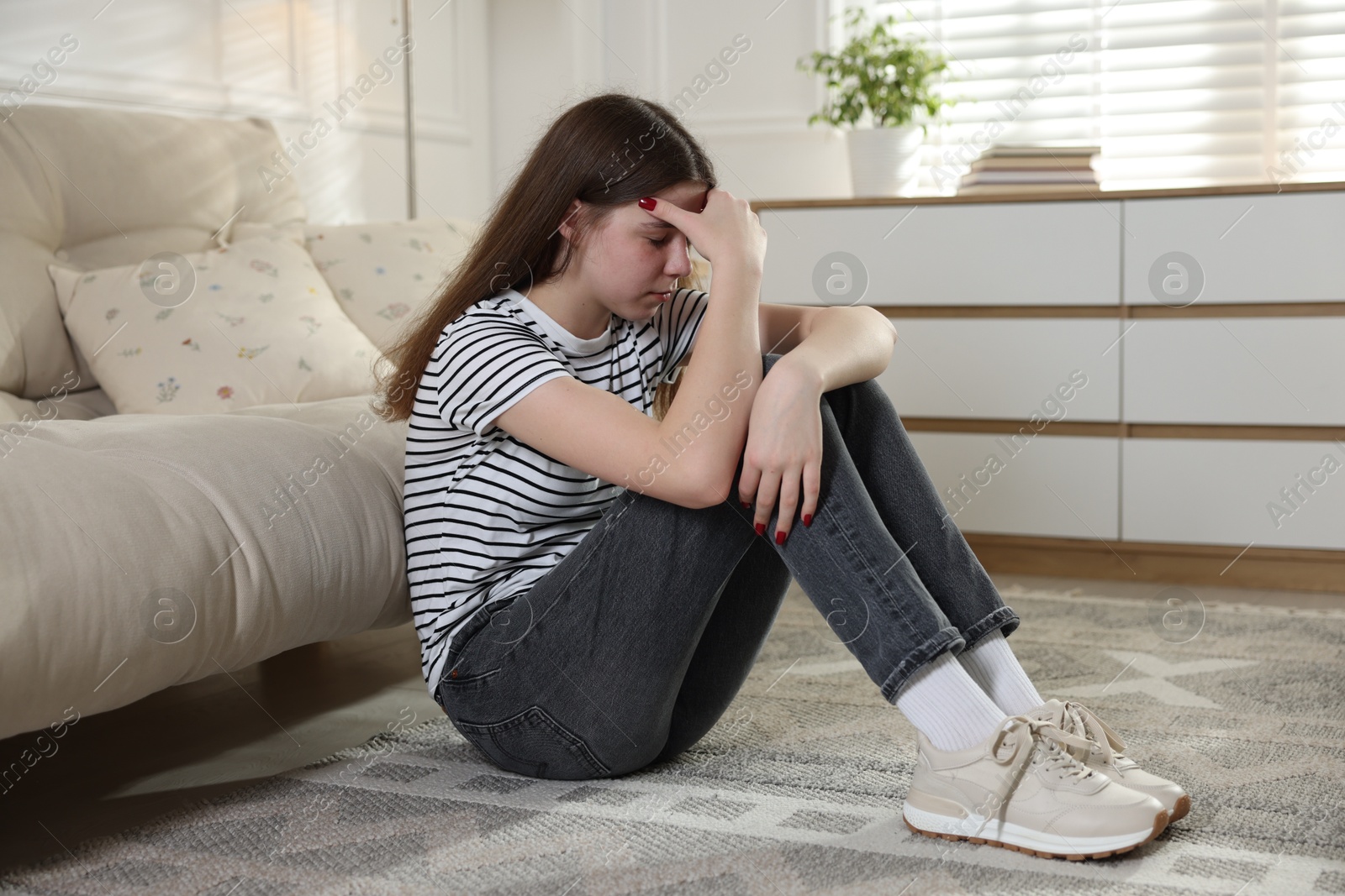 Depressed teenage girl on floor at home Photo of Depressed teenage girl on floor at home