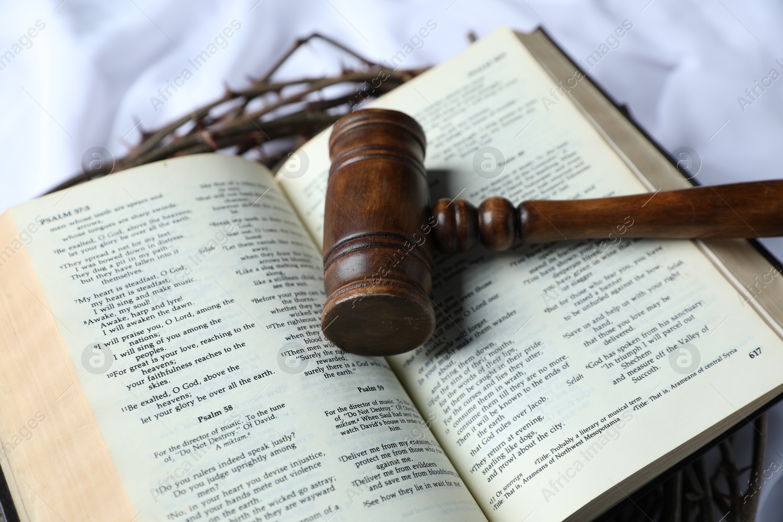 Judge's gavel, crown of thorns and Bible on white fabric, closeup Photo of Judge's gavel, crown of thorns and Bible on white fabric, closeup