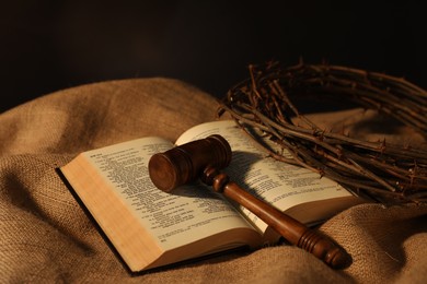 Photo of Judge's gavel, Bible and crown of thorns on burlap fabric