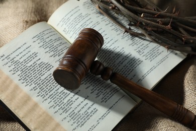 Photo of Judge's gavel, Bible and crown of thorns on burlap fabric, above view