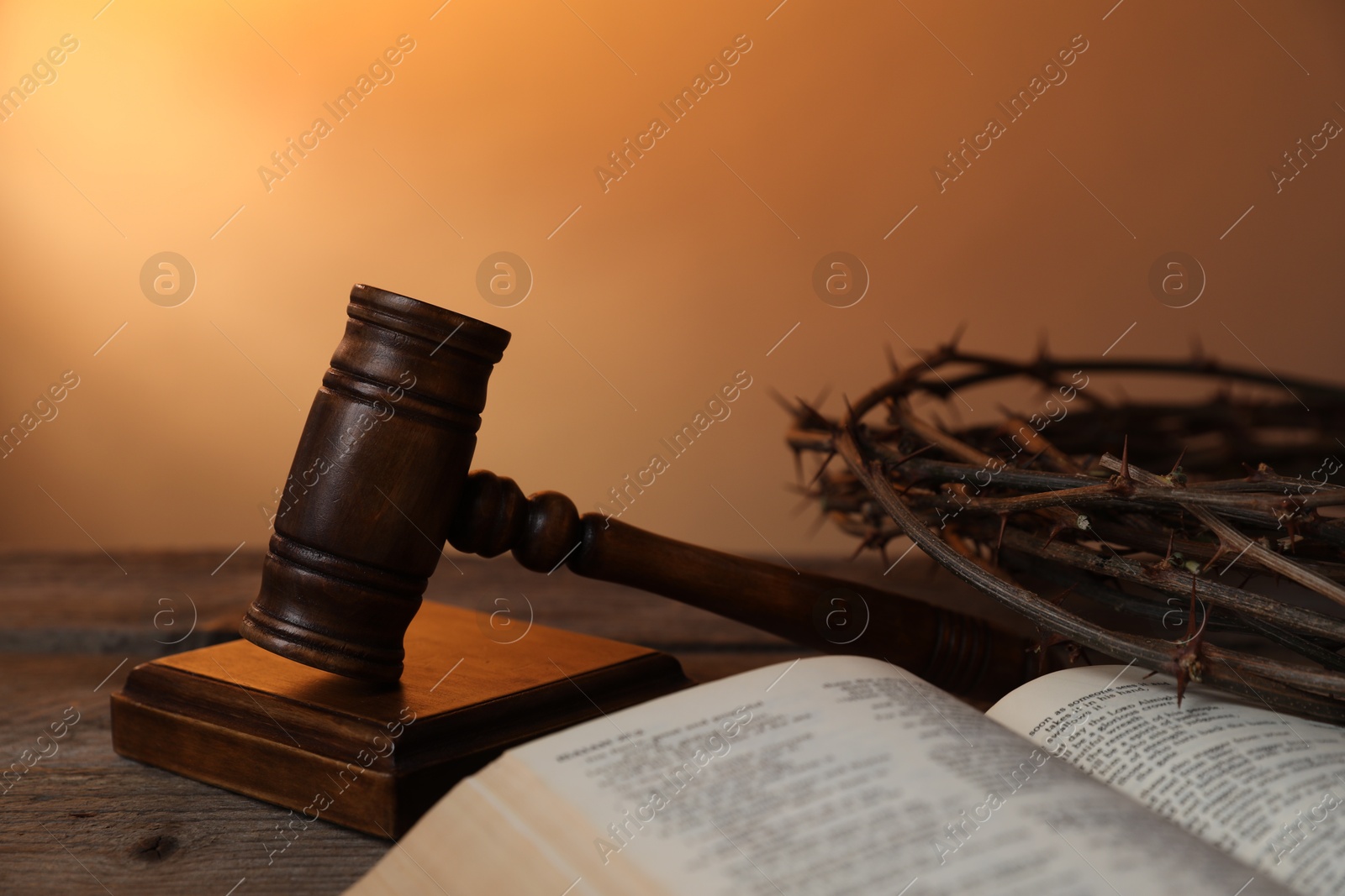 Judge's gavel, crown of thorns and Bible on wooden table against pale orange gradient background, closeup Photo of Judge's gavel, crown of thorns and Bible on wooden table against pale orange gradient background, closeup
