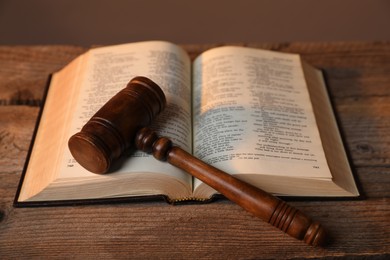 Photo of Judge's gavel and Bible on wooden table, closeup