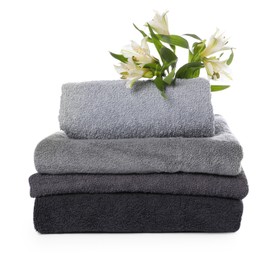 Photo of Stack of towels and beautiful flowers isolated on white