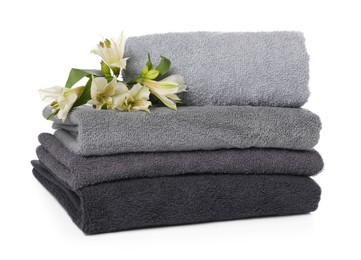 Photo of Stack of towels and beautiful flowers isolated on white