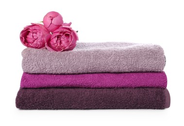 Photo of Stack of towels and peony flowers isolated on white