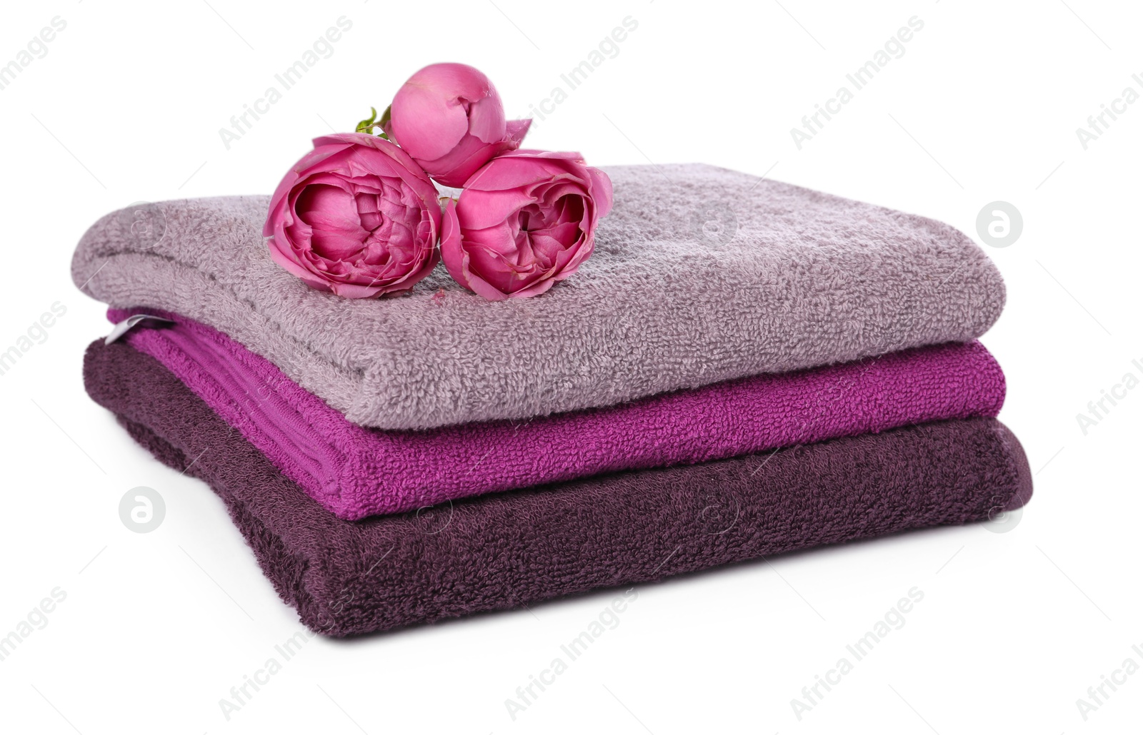 Stack of towels and peony flowers isolated on white Photo of Stack of towels and peony flowers isolated on white