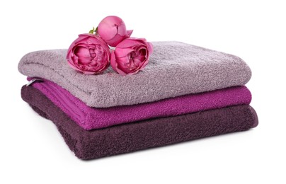 Photo of Stack of towels and peony flowers isolated on white
