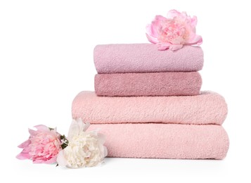 Photo of Stack of towels and peony flowers isolated on white