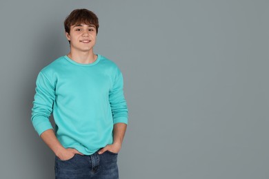 Photo of Portrait of teenage boy on grey background. Space for text