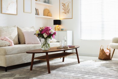 Photo of Bouquet of beautiful peonies and water on coffee table indoors. Interior design