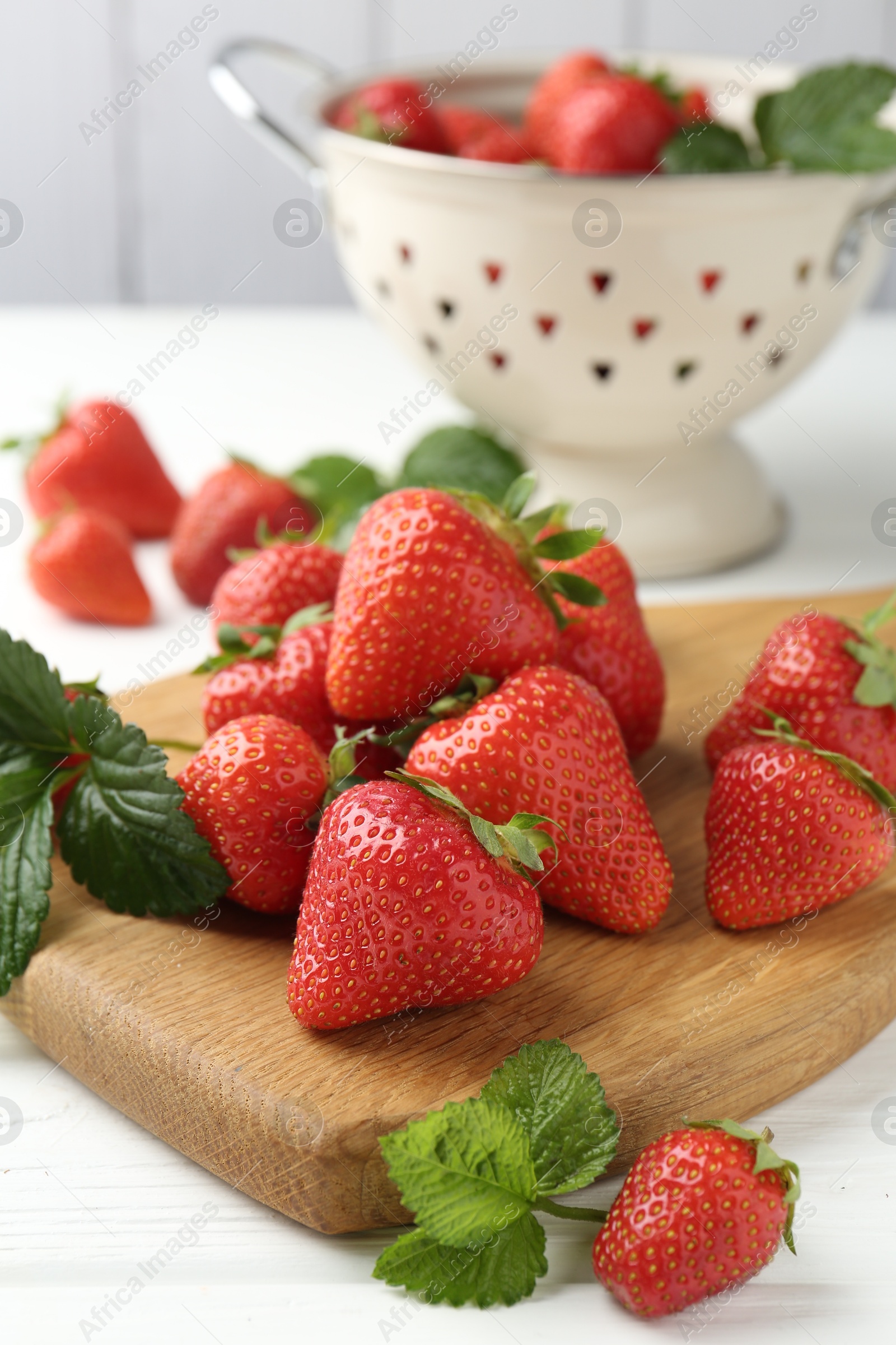 Fresh ripe strawberries and leaves on white wooden table, closeup Photo of Fresh ripe strawberries and leaves on white wooden table, closeup