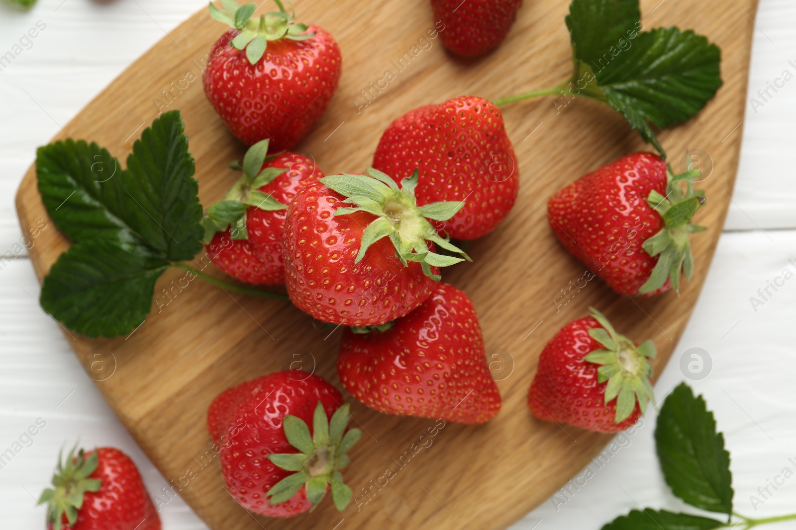 Fresh ripe strawberries and leaves on white wooden table, top view Photo of Fresh ripe strawberries and leaves on white wooden table, top view