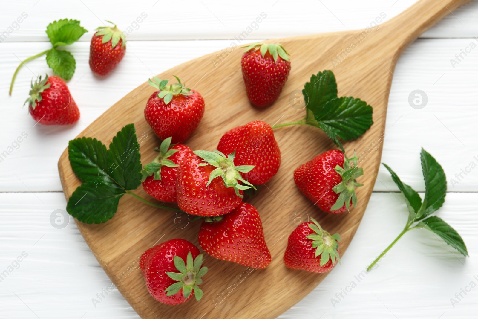 Fresh ripe strawberries and leaves on white wooden table, top view Photo of Fresh ripe strawberries and leaves on white wooden table, top view